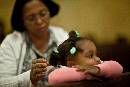 Child in Pink (1200Wx800H) - Woman Touching Child in Pink - Day of the Dead - Church of the Visitation - 2009 